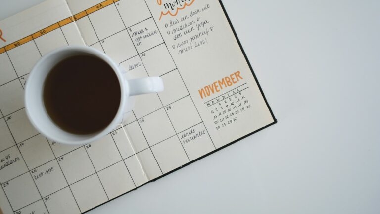 Agenda ouvert et tasse de café sur un bureau