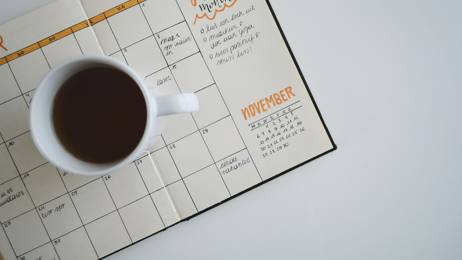 Agenda ouvert et tasse de café sur un bureau
