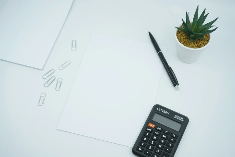 Calculatrice et stylo posés sur une feuille de calcul