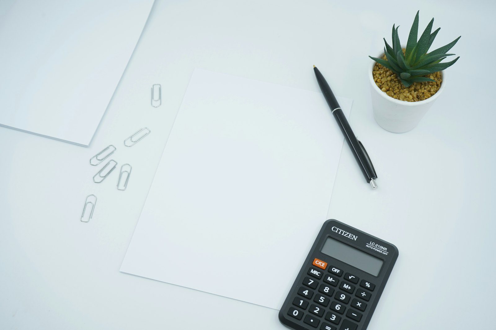 Calculatrice et stylo posés sur une feuille de calcul