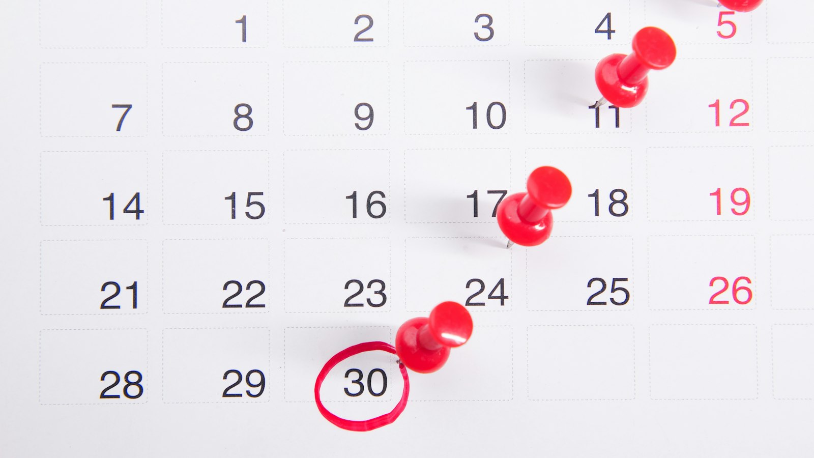 Calendrier avec des punaises rouges