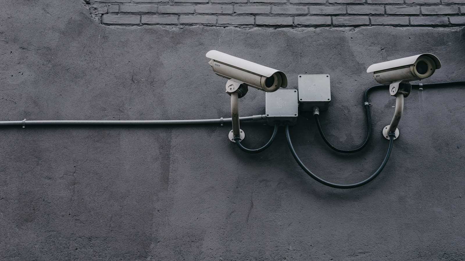 Deux caméras de surveillance fixées à un mur