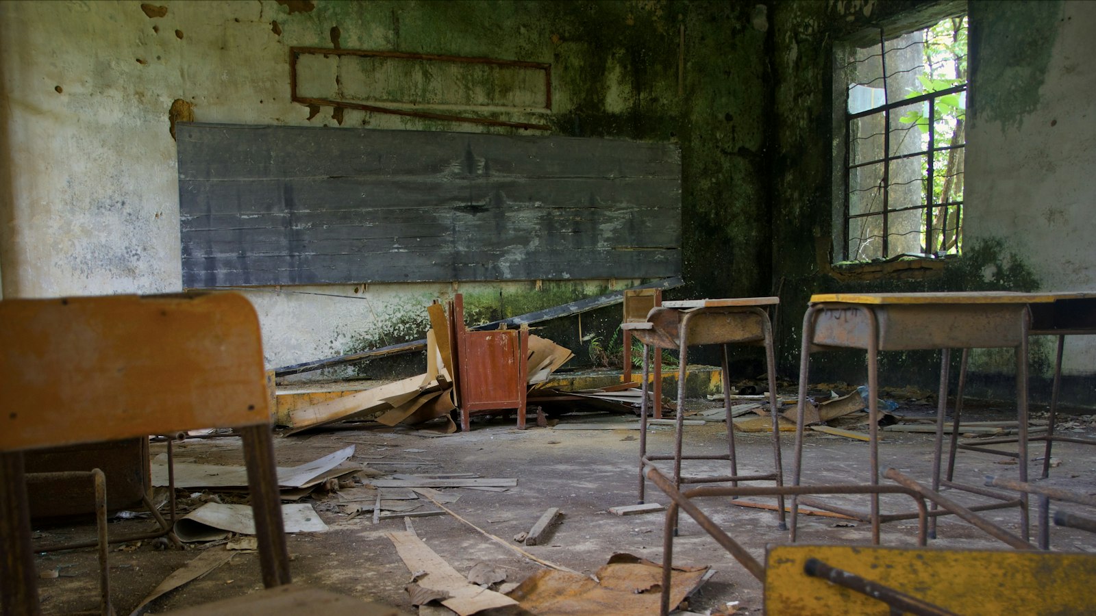 Salle de classe délabrée avec des bancs et des débris