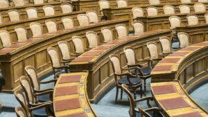 Rangées de sièges en bois dans un hémicycle parlementaire