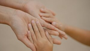 Mains d’un adulte et d’un enfant superposées