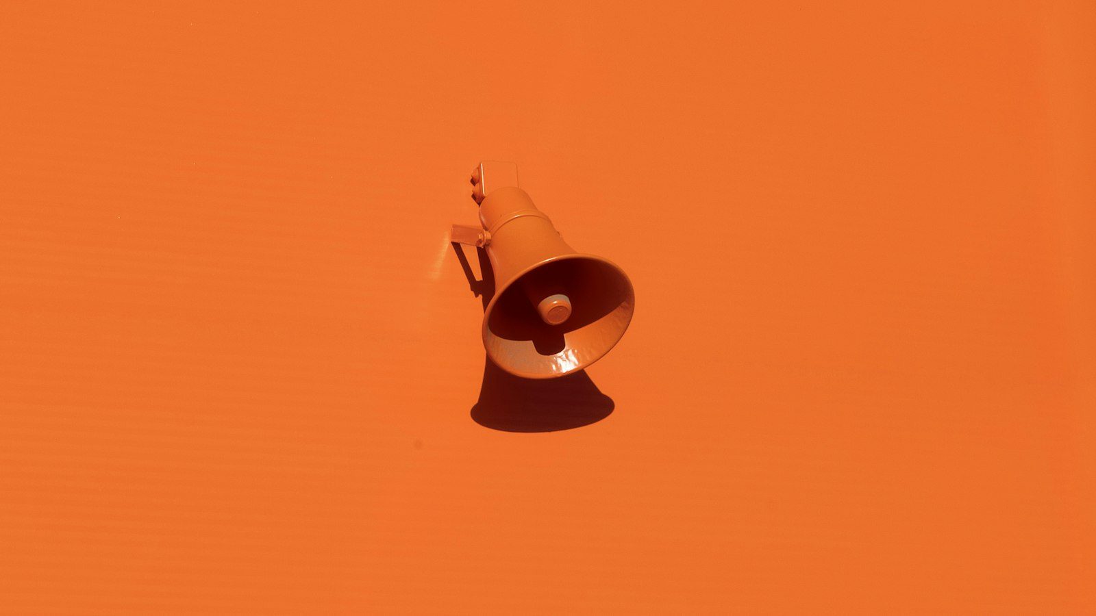 Mégaphone orange sur un mur orange