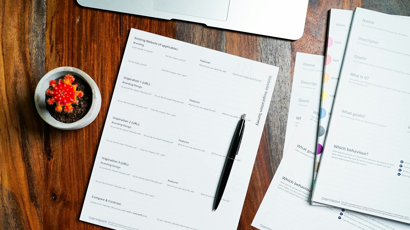 Feuilles de papier et stylo posés sur une table en bois