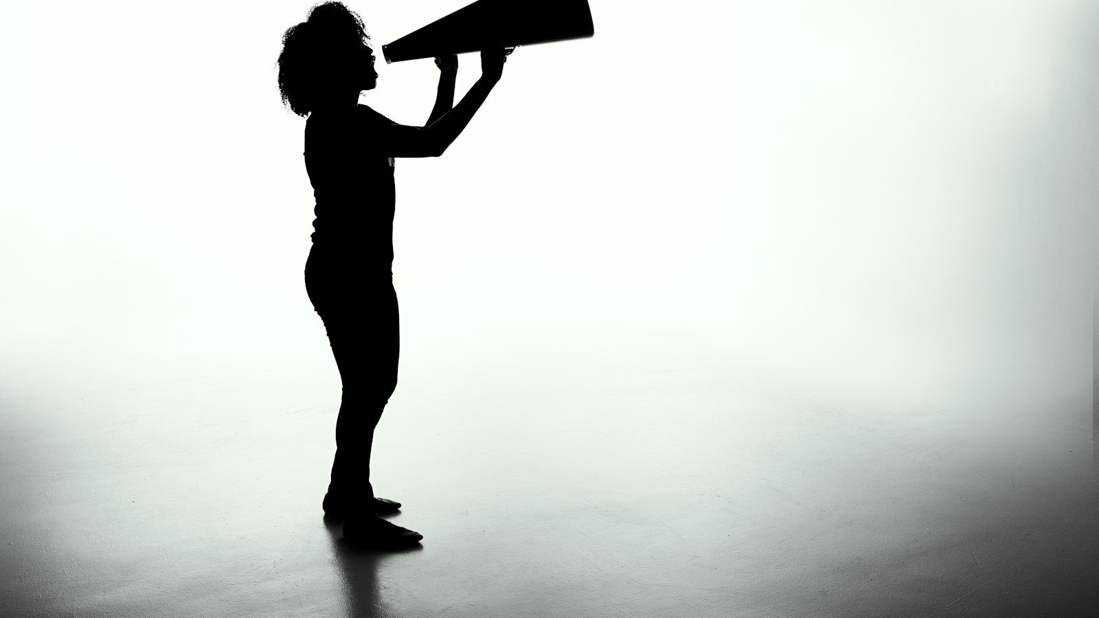 Silhouette d’une personne parlant dans un mégaphone